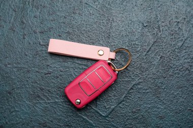 Arka planda deri anahtarlık olan araba anahtarı.