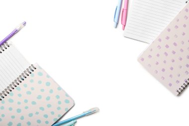 Beyaz arkaplanda stil defterleri ve kalemler, yakın plan