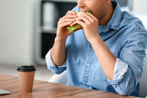 Jeune Homme Mangeant Sandwich Savoureux Bureau — Photo