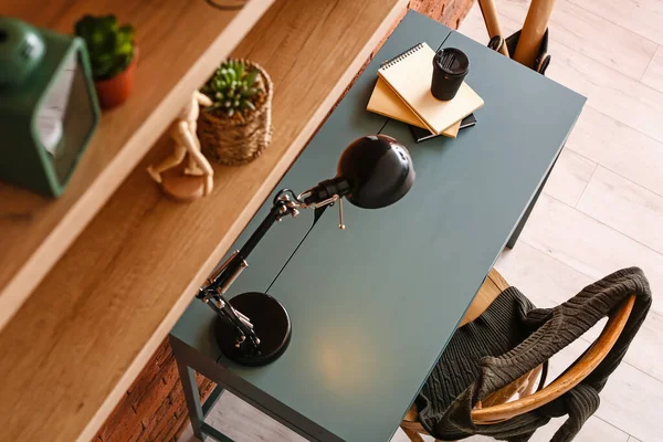 Elegante Lugar Trabajo Con Lámpara Taza Papel Café Libros Mesa —  Fotos de Stock