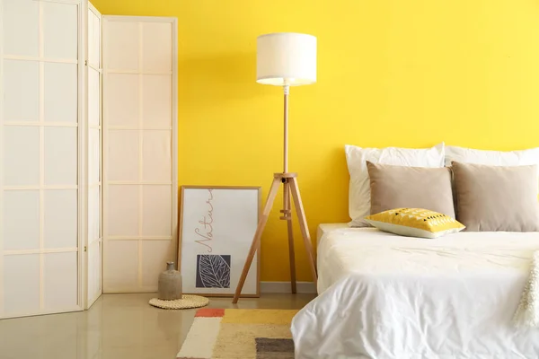 快適なベッドルーム 床ランプ カラーウォールの近くの屏風付きのスタイリッシュなベッドルーム — ストック写真