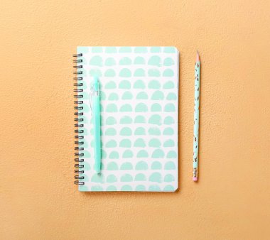 Renkli arka plan üzerinde stil defteri, kalem ve kalem