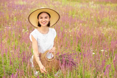 Yaz günü çantasında çiçeklerle güzel bir genç kadın.