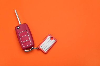 Turuncu arka planda plastik etiketli araba anahtarı