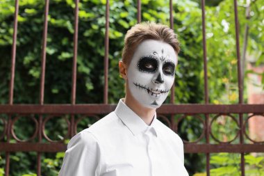 Yüzünde boyalı kafatası olan genç bir adam. Meksika Ölüler Günü 'nün Kutlaması (El Dia de Muertos)