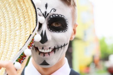 Yüzünde boyalı kafatası olan genç bir adam. Meksika Ölüler Günü 'nün Kutlaması (El Dia de Muertos)