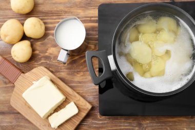 Taze ürünler ve haşlanmış patatesle birlikte mutfakta elektrikli soba.