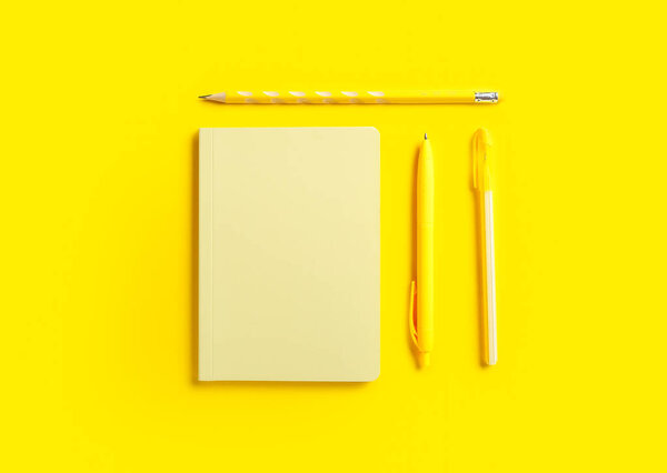 Stylish notebook, pens and pencil on color background