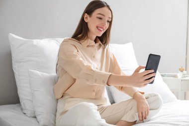 Genç bir kadının evde görüntülü konuşması.