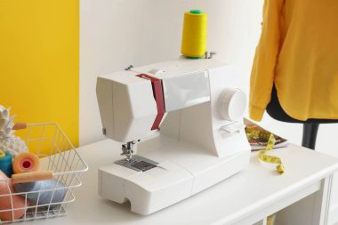 Modern dikiş makinesi terzi atölyesinde, yakın plan.