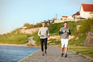 Nehir kenarında koşan genç sporcular