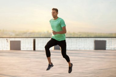 Nehir kenarında koşan yakışıklı genç adam