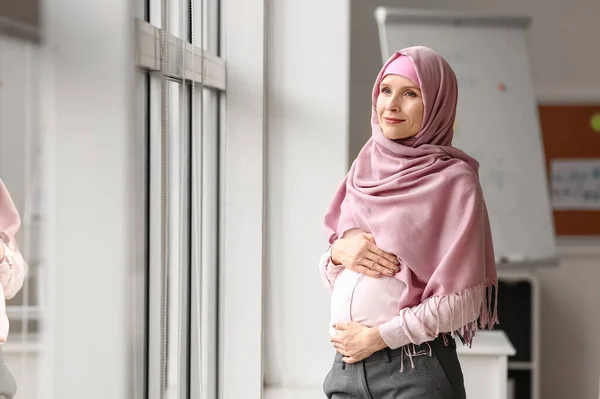 妊娠中のイスラム教徒の女性がオフィスの窓の近く — ストック写真