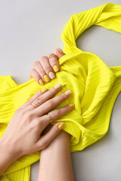 Kobieta Pięknym Manicure Gospodarstwa Ubrania Jasnym Tle — Zdjęcie stockowe