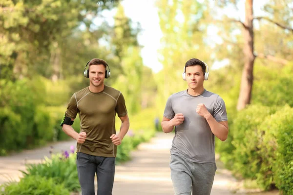 Jóvenes Deportivos Con Auriculares Corriendo Parque —  Fotos de Stock