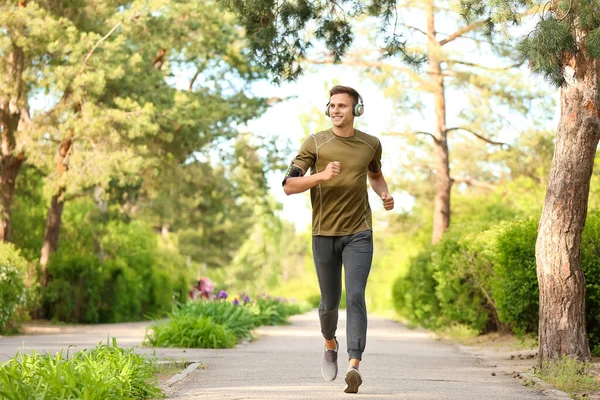 Sportlicher Junger Mann Mit Kopfhörern Läuft Park — Stockfoto