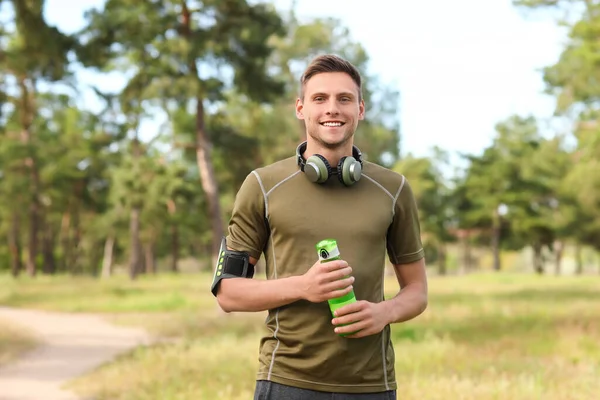 Joven Deportivo Con Botella Agua Auriculares Parque —  Fotos de Stock