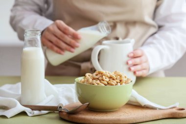 Lezzetli mısır halkalı kase, renkli masada kaşık ve şişe.