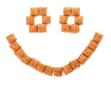 Beyaz arka planda çikolatalı mısır yastığından yapılmış gülümseme