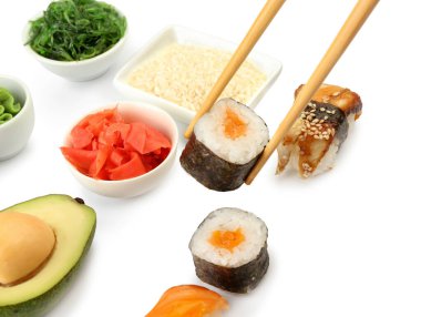 Çubuklar somon balığıyla maki dürümü alıyor, yakın plan.