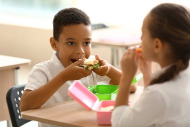Okulda öğle yemeği yiyen şirin çocuklar.