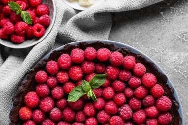 Lezzetli ahududu turtası ve nane arkaplanlı tabak, yakın plan.