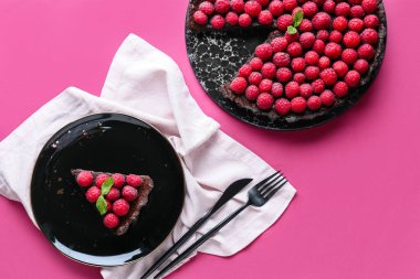 Renkli arkaplanda lezzetli ahududu turtası ve nane şekerli tabak.