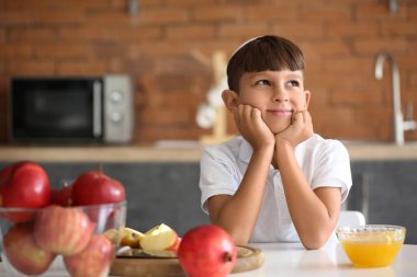 Evde elma, bal ve nar taşıyan küçük bir çocuk. Rosh Hashanah (Yahudi Yeni Yılı) kutlaması