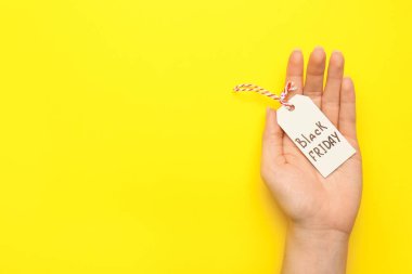 Renk arkaplanı üzerinde metin Kara Cuma ile kadın el ele etiketi