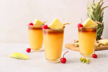 Lezzetli mai tai kokteyli bardakları kiraz ve ananas dilimleriyle süslenmiş.