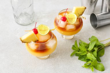 Kiraz ve ananas dilimleriyle süslenmiş şık mai tai kokteylleri.