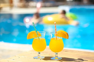 Yüzme havuzunun yanındaki masada bir bardak kokteyl.