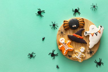 Cadılar Bayramı kutlaması için arkaplanda lezzetli kurabiyeler olan tahta