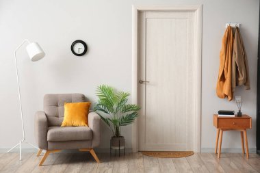 Koridorun içinde koltuk, masa ve kapı paspası var.