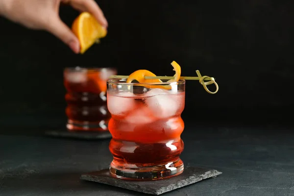 Vrouw Knijpen Verse Sinaasappel Glas Met Smakelijke Negroni Cocktail Donkere — Stockfoto