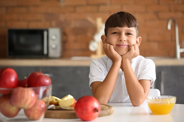 Little boy with apples, honey and pomegranates at home. Rosh Hashanah (Jewish New Year) celebration