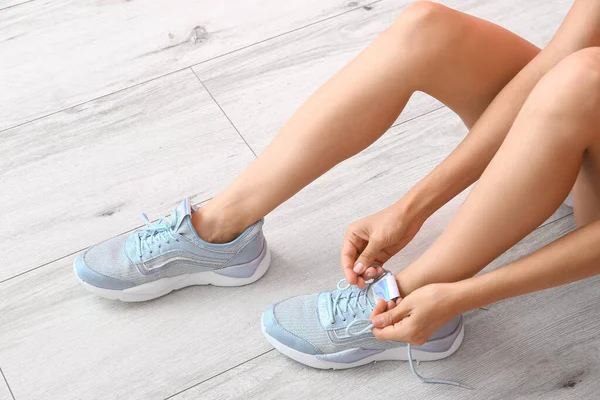 Young Woman Tying Shoe Laces Indoors — Stock Photo, Image