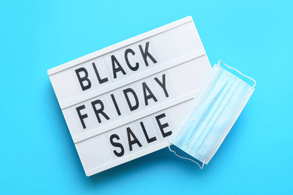 Доска с текстом Черная пятница Продажа и медицинская маска на цветном фоне