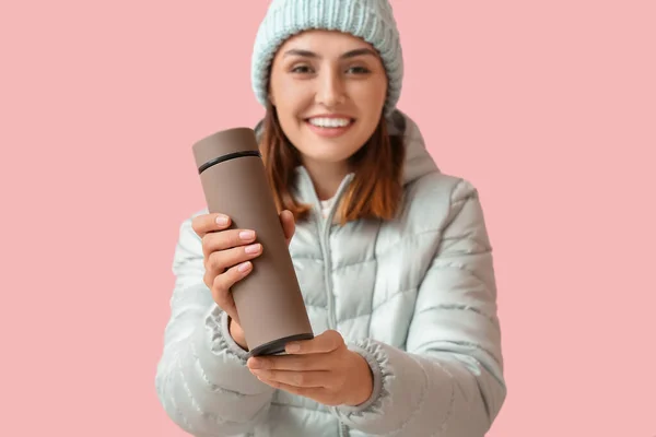 暖かい服の若い女性と色の背景に魔法瓶 — ストック写真