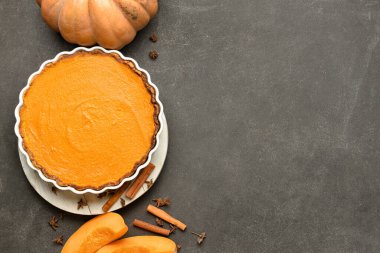 Lezzetli balkabağı turtası ve siyah arka planda taze sebze ile pişirme yemeği.