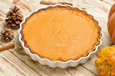 Beyaz ahşap zemin üzerinde lezzetli kabak turtası olan fırın tabağı.