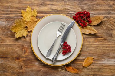 Rowan 'la masa ayarı ve ahşap arka planda sonbahar yaprakları