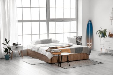 Sörf tahtası olan modern şık bir yatak odası.