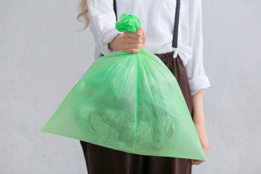 Elinde çöp torbası olan bir kadın, yakın plan.