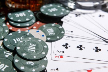 Poker fişleri ve kartlar masada, yakın plan