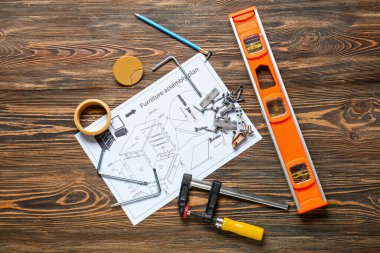 Ahşap zemin üzerinde mobilya montaj planı ve farklı araçlar kümesi