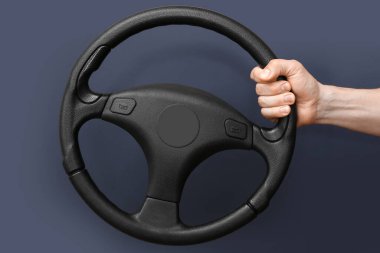 Karanlık arka planda modern direksiyon tutan adam.