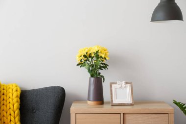 Oturma odasındaki ışıklı duvarın yanındaki çekmecelerin üstündeki vazo çok şık.