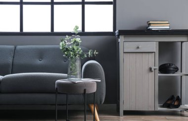 Kaliteli oturma odasının duvarının yanında okaliptüs kaplı cam vazo.