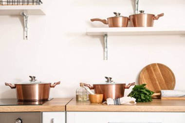 Mutfak tezgahında havan, tokmak, ıspanak ve yağlı tencere seti.